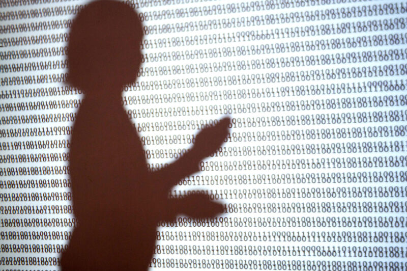The silhouette of a child against a wall covered in ones and zeroes.